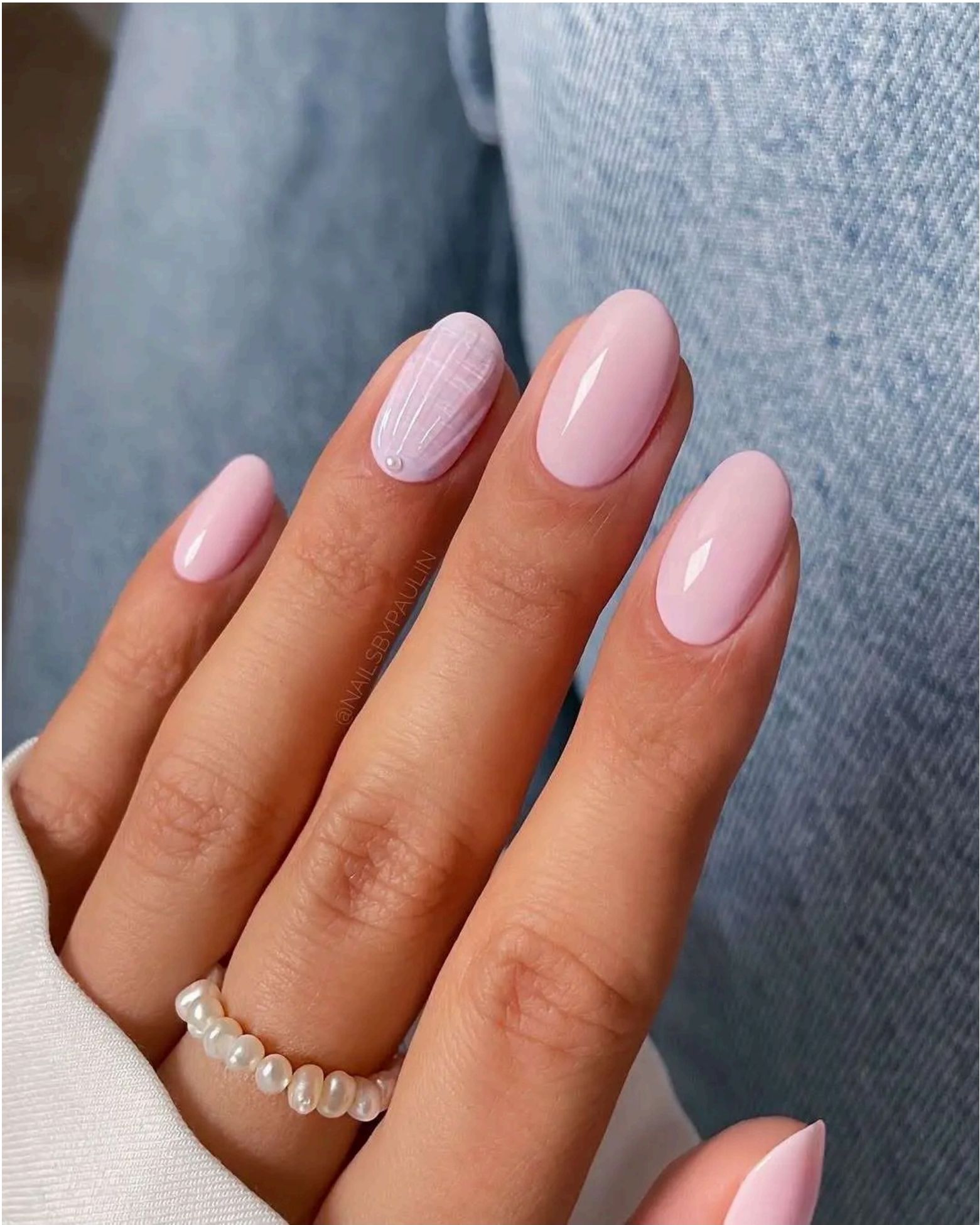 Soft pink nails with delicate white striped accent and pearl detail – minimal beach beauty.