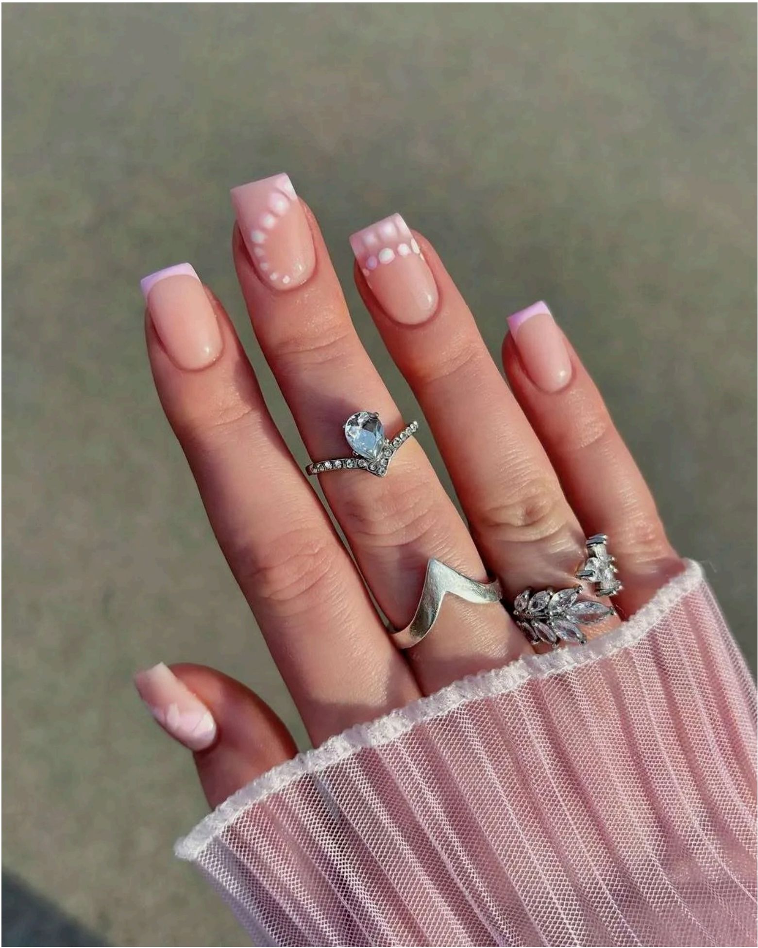 Classic pink and white French tips with delicate pearl dots tracing elegant curves – subtle beach bride vibes.